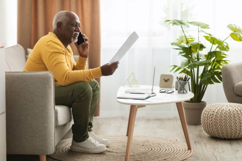 senior man on phone while looking at documents
