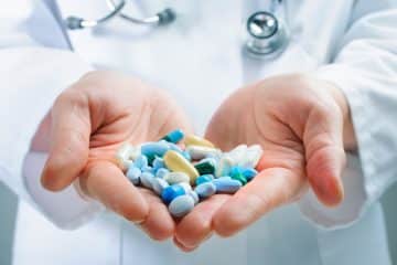 A pharmacist holding a prescription pills.