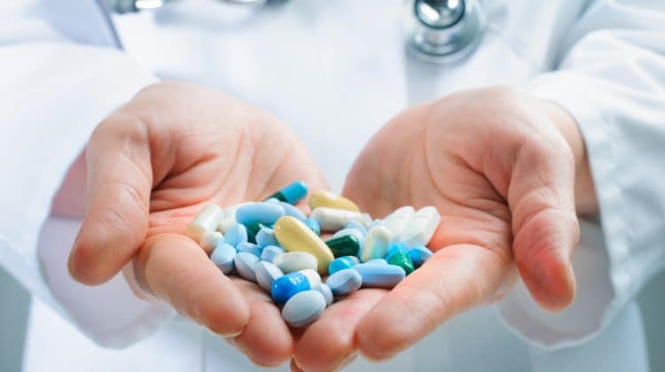 A pharmacist holding a prescription pills.