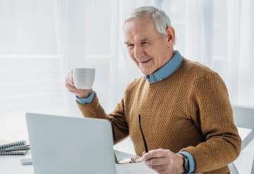 A senior man working at a laptop.